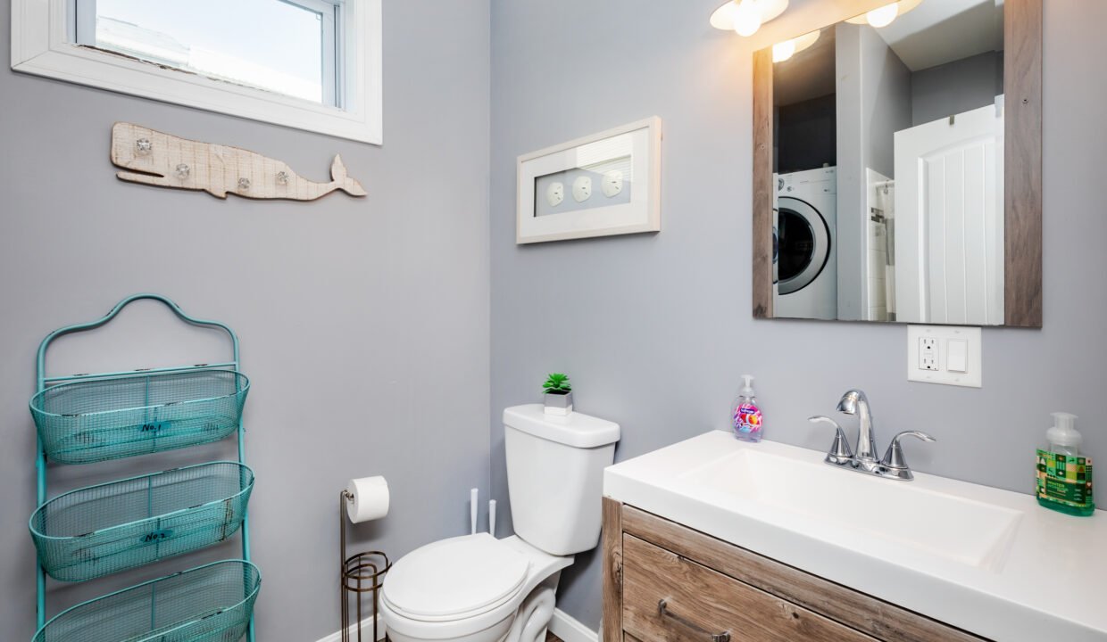 A bathroom with a washer and dryer and a window.