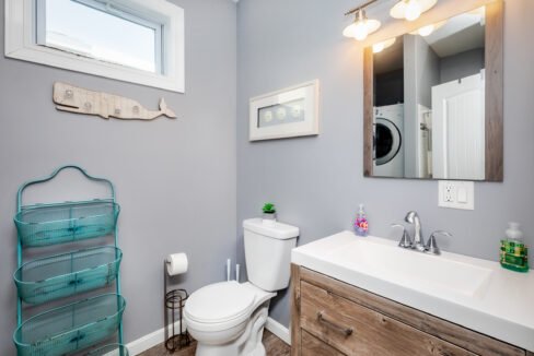 A bathroom with a washer and dryer and a window.