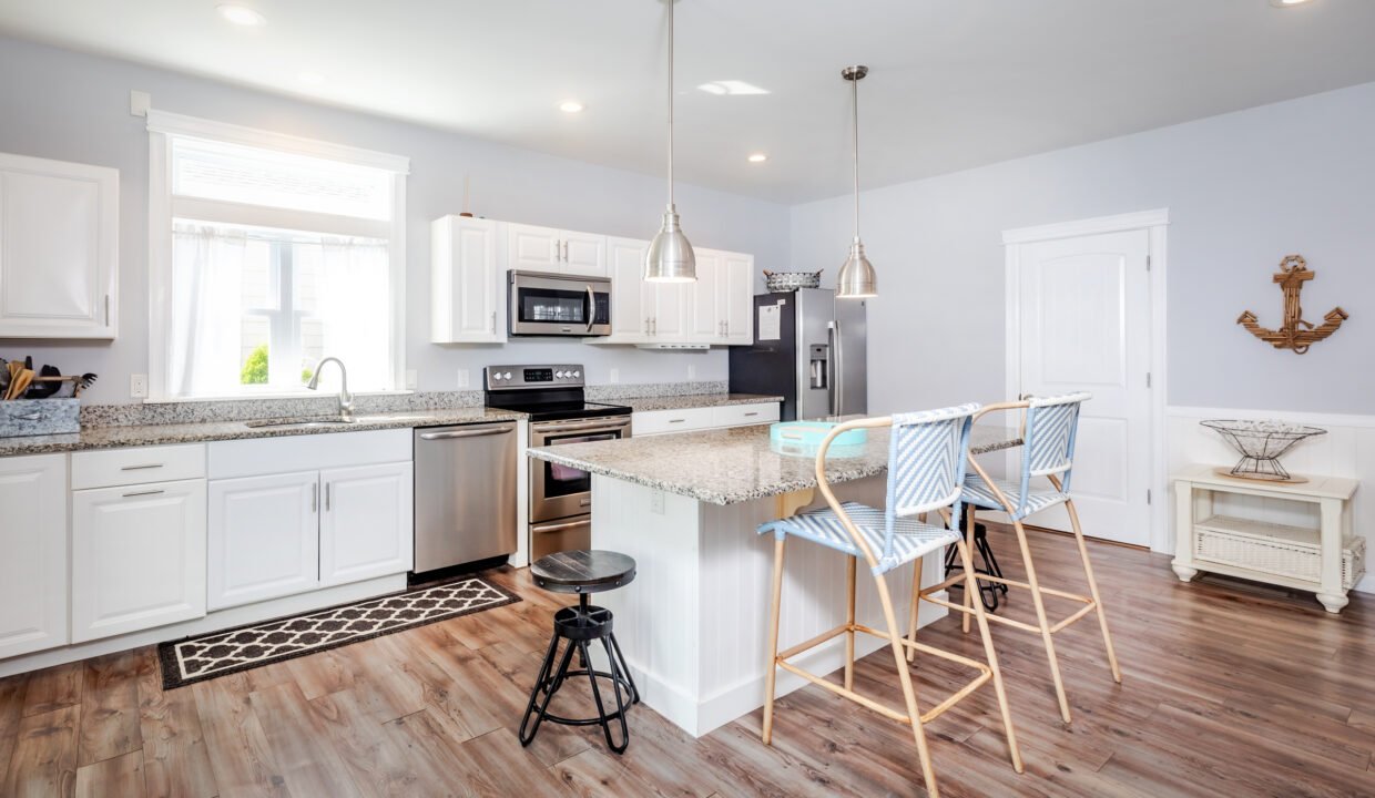 A kitchen with wood floors and a bar stools.