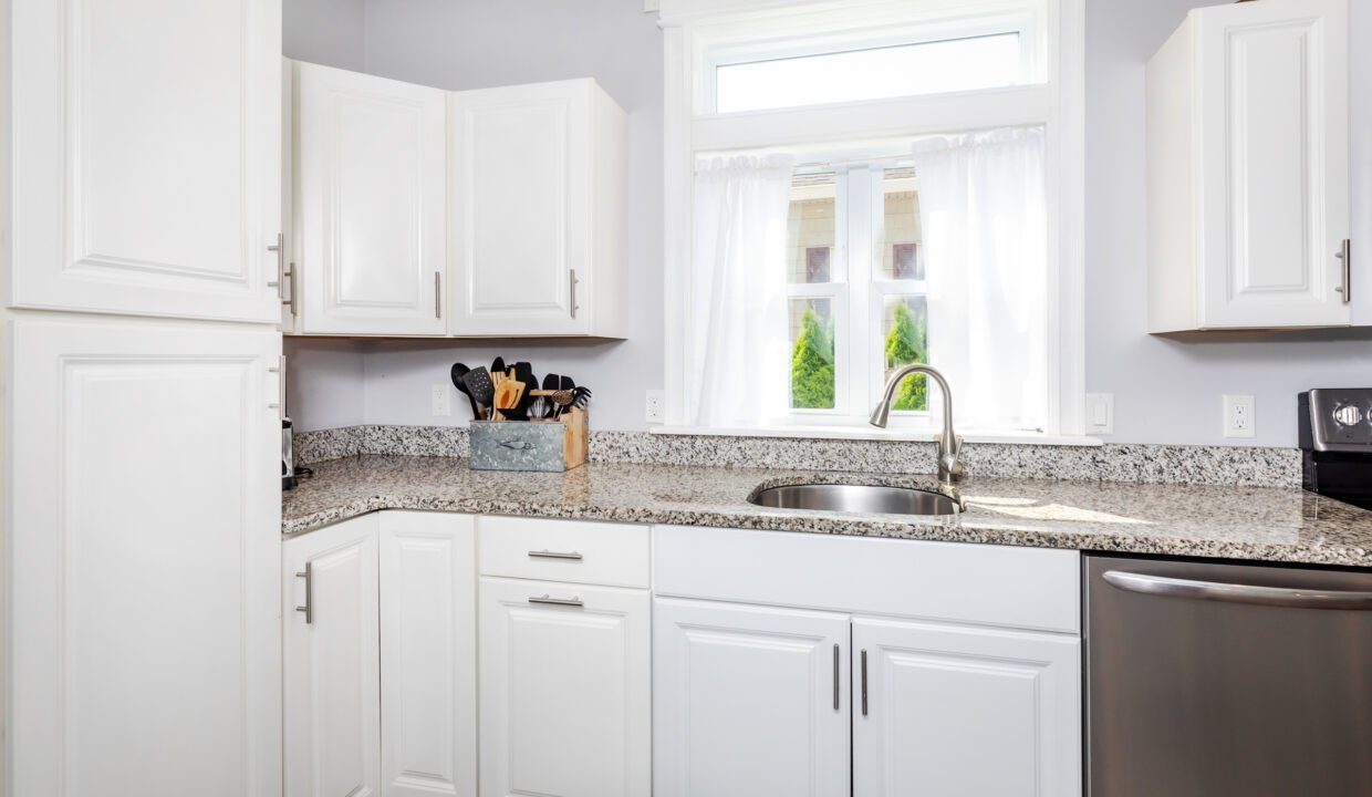 A kitchen with white cabinets and stainless steel appliances.