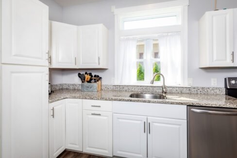 A kitchen with white cabinets and stainless steel appliances.