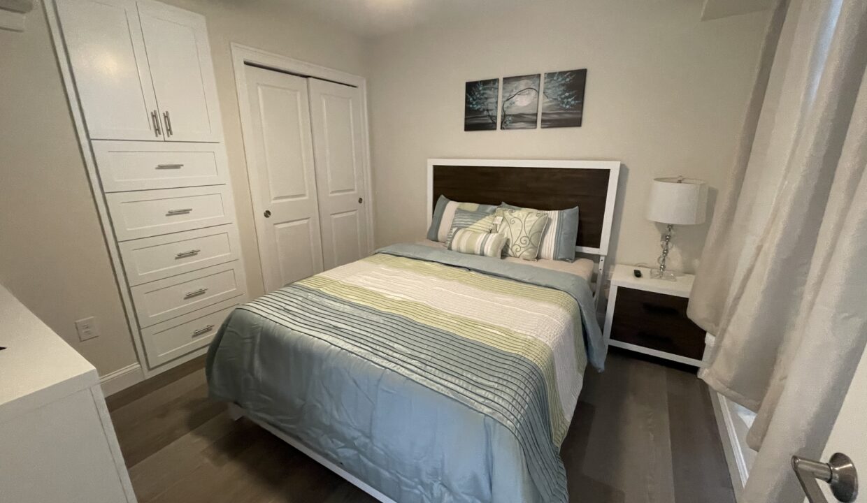 a bedroom with a neatly made bed and a ceiling fan.