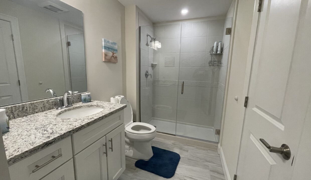 a bathroom with a sink, toilet, and shower.