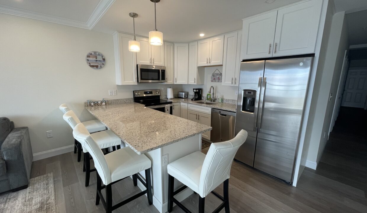 a kitchen with a center island and a stainless steel refrigerator.