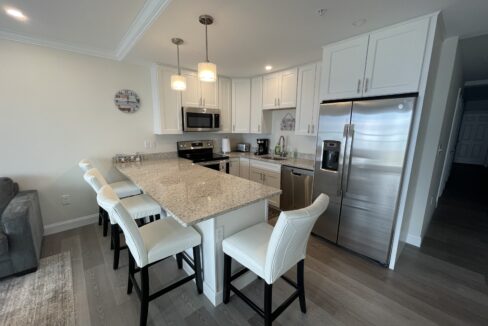 a kitchen with a center island and a stainless steel refrigerator.