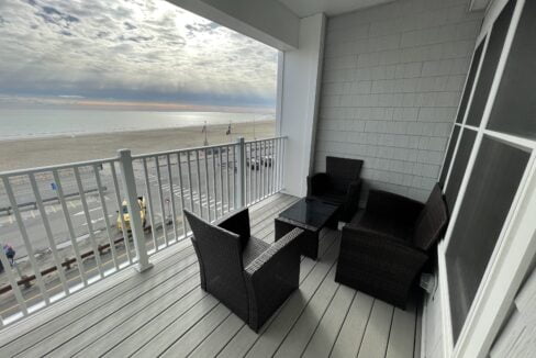 a balcony with wicker furniture and a view of the beach.