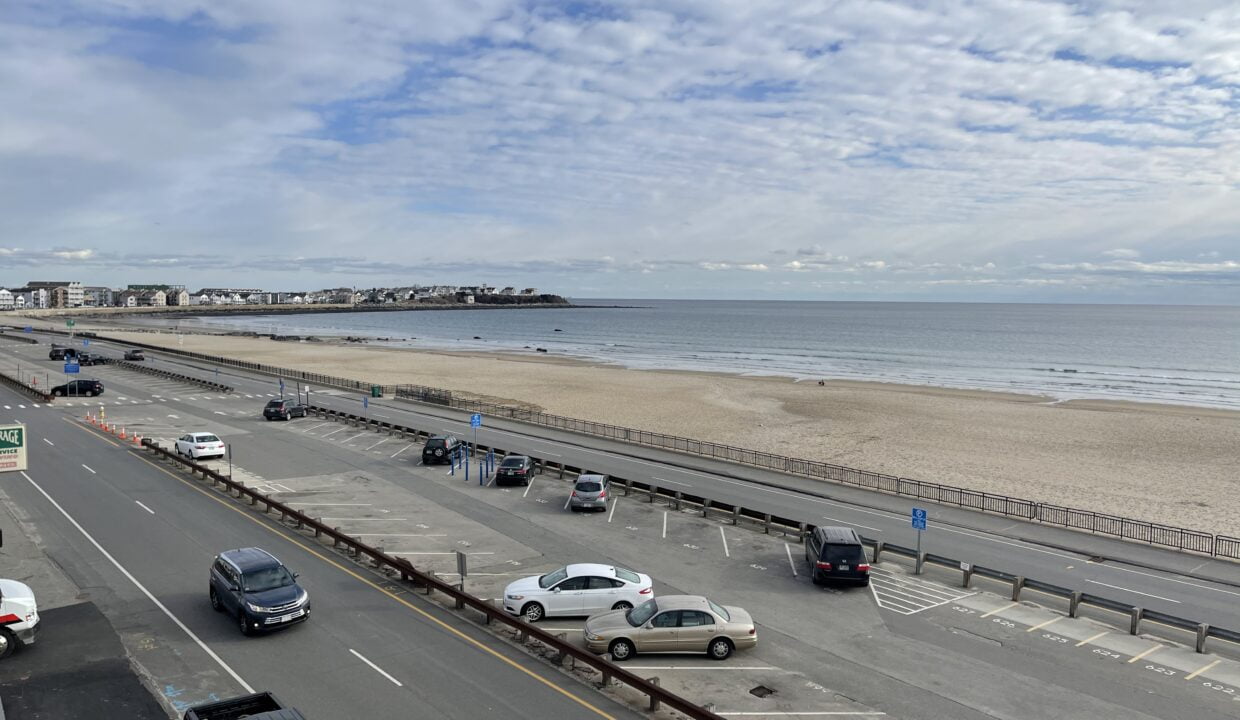 a highway with cars driving down it next to the beach.