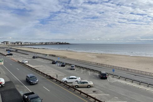 a highway with cars driving down it next to the beach.