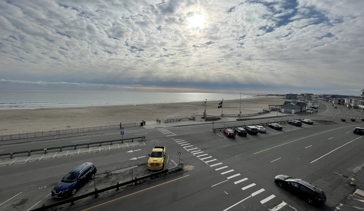 a parking lot with cars parked on the side of the road.