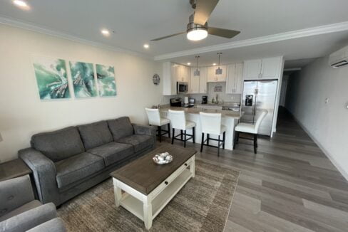 a living room filled with furniture next to a kitchen.