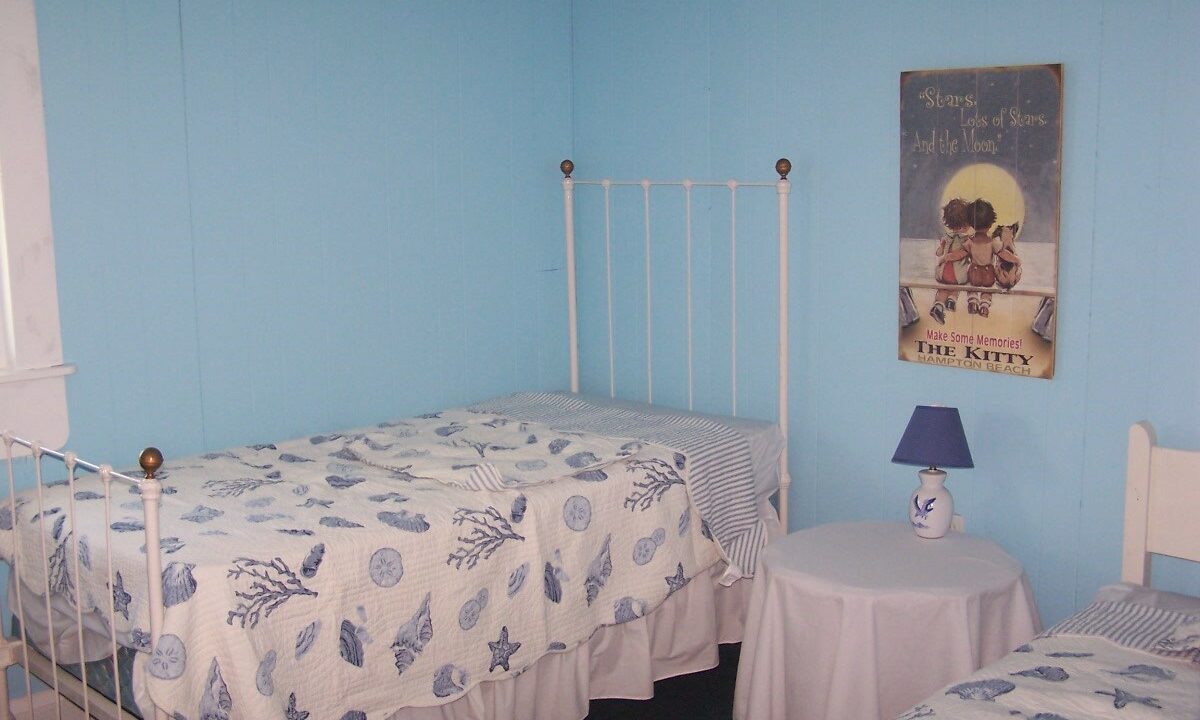 a bedroom with two beds and a picture on the wall.