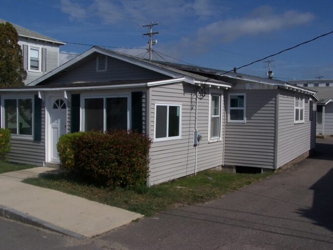 a gray house with a white door and windows.