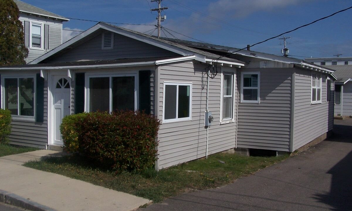 a gray house with a white door and windows.