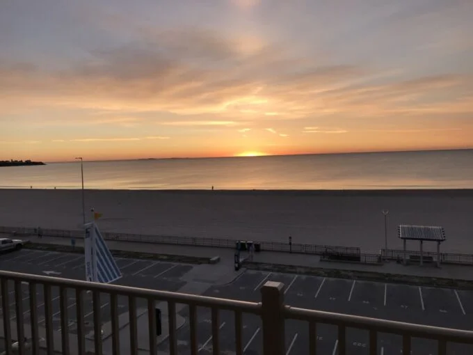 a view of a beach from a balcony at sunset.