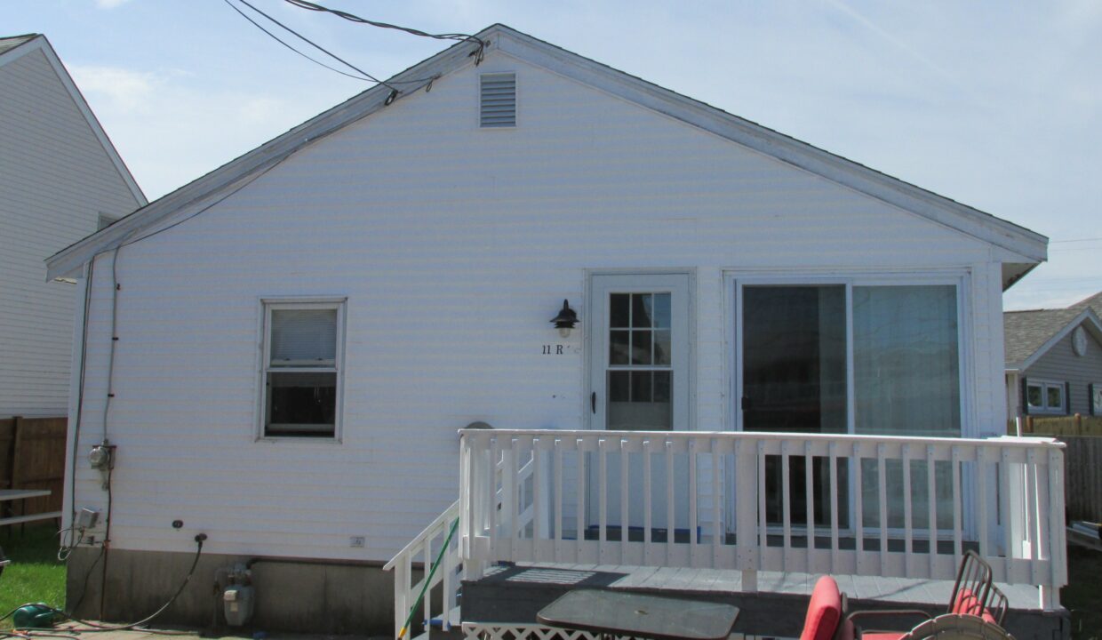 a white house with a porch and a white fence.