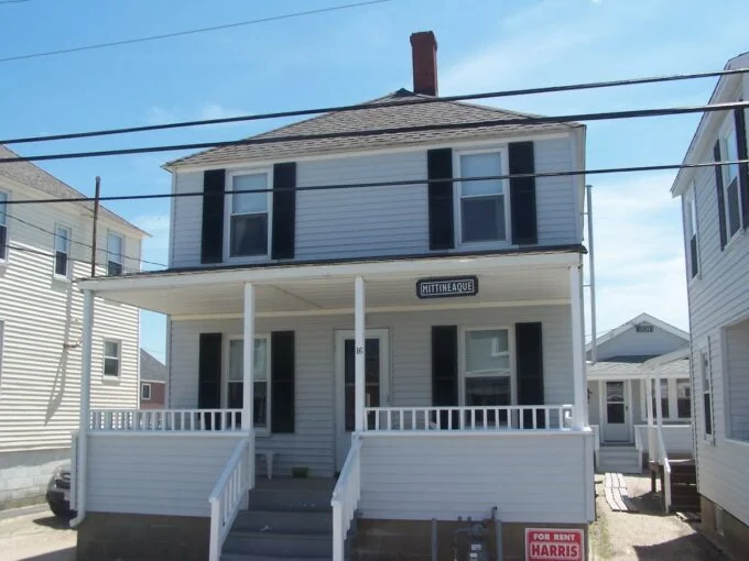 a white two story house with black shutters.