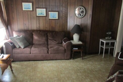 a living room with a brown couch and a table.