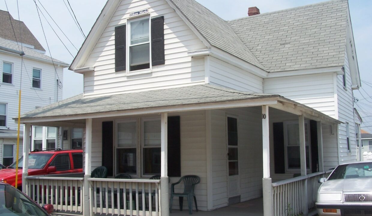 a white house with a porch and a covered porch.