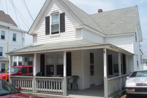 a white house with a porch and a covered porch.