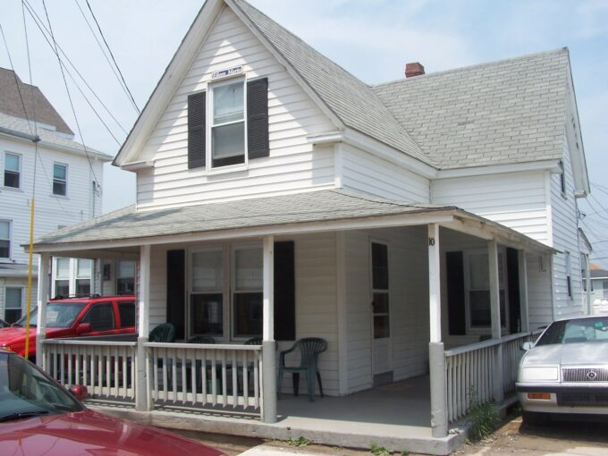 a white house with a porch and a covered porch.