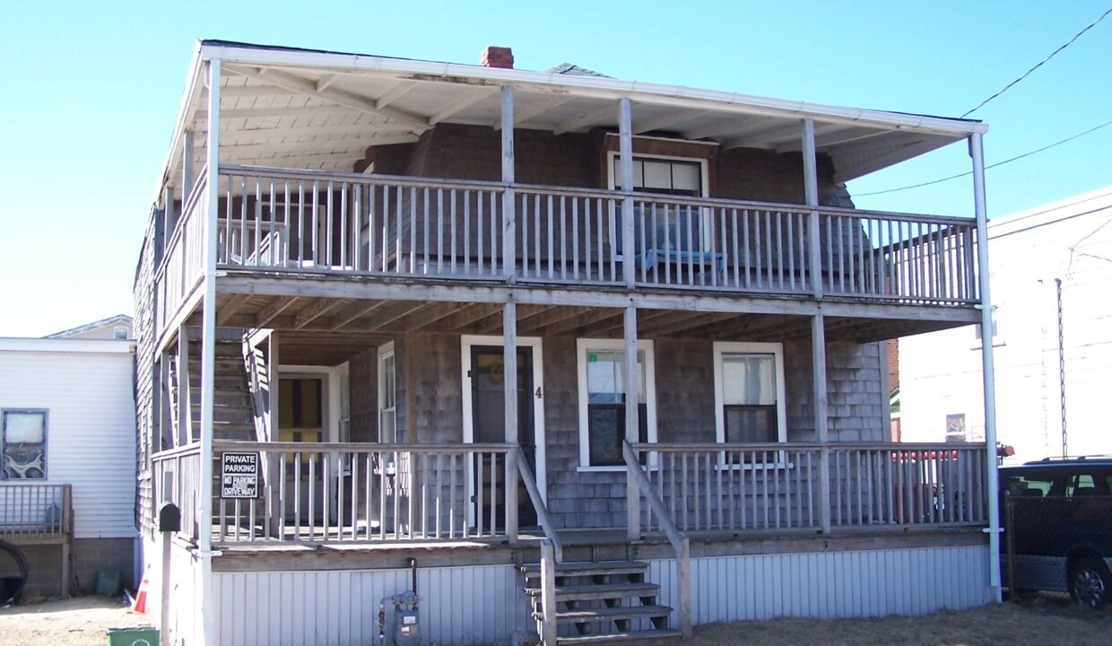 a two story house with a porch and stairs.