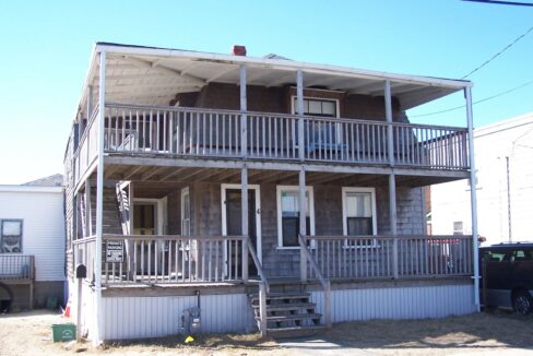 a two story house with a porch and stairs.