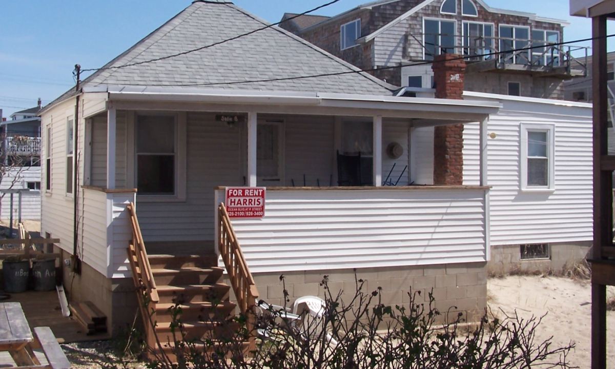 a house with a for sale sign in front of it.