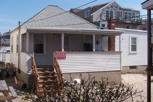 a house with a for sale sign in front of it.