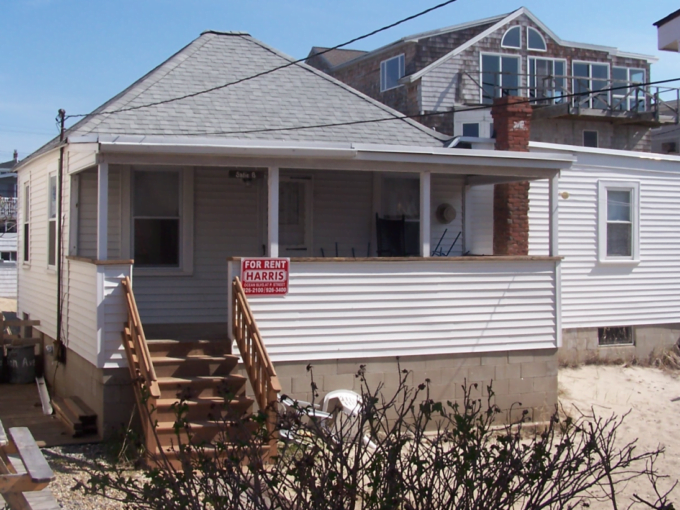 a house with a for sale sign in front of it.