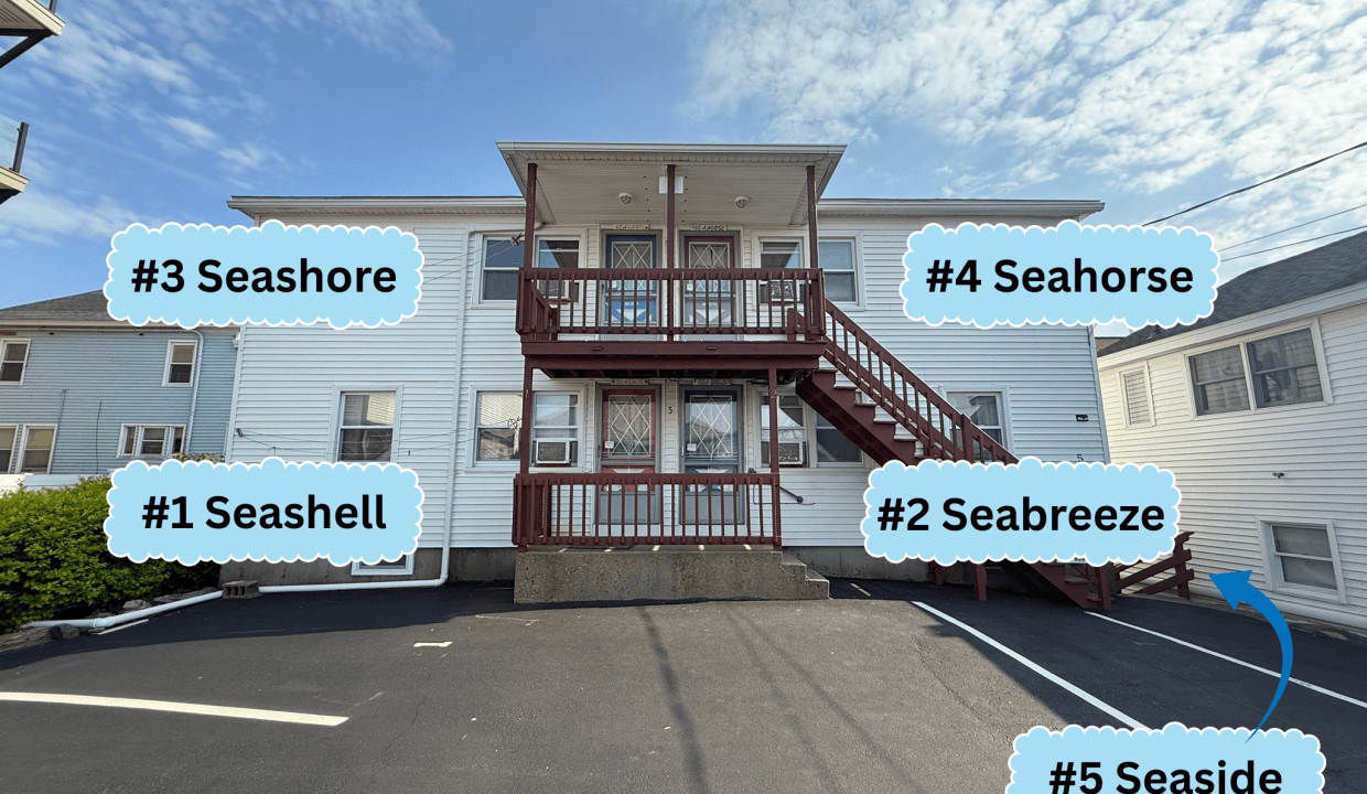 A two-story white building with exterior stairs, five labeled units (#1 Seashell, #2 Seabreeze, #3 Seashore, #4 Seahorse, #5 Seaside), and a paved parking area.
