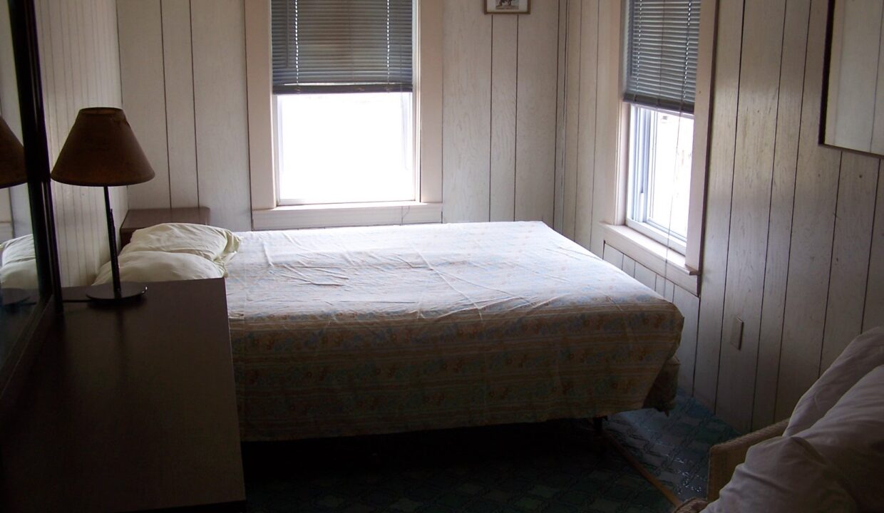 a bed sitting in a bedroom next to a window.