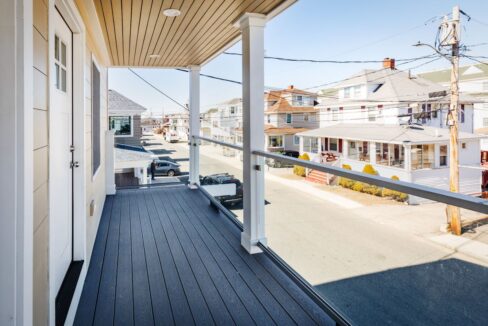 a balcony with a view of a street and houses.