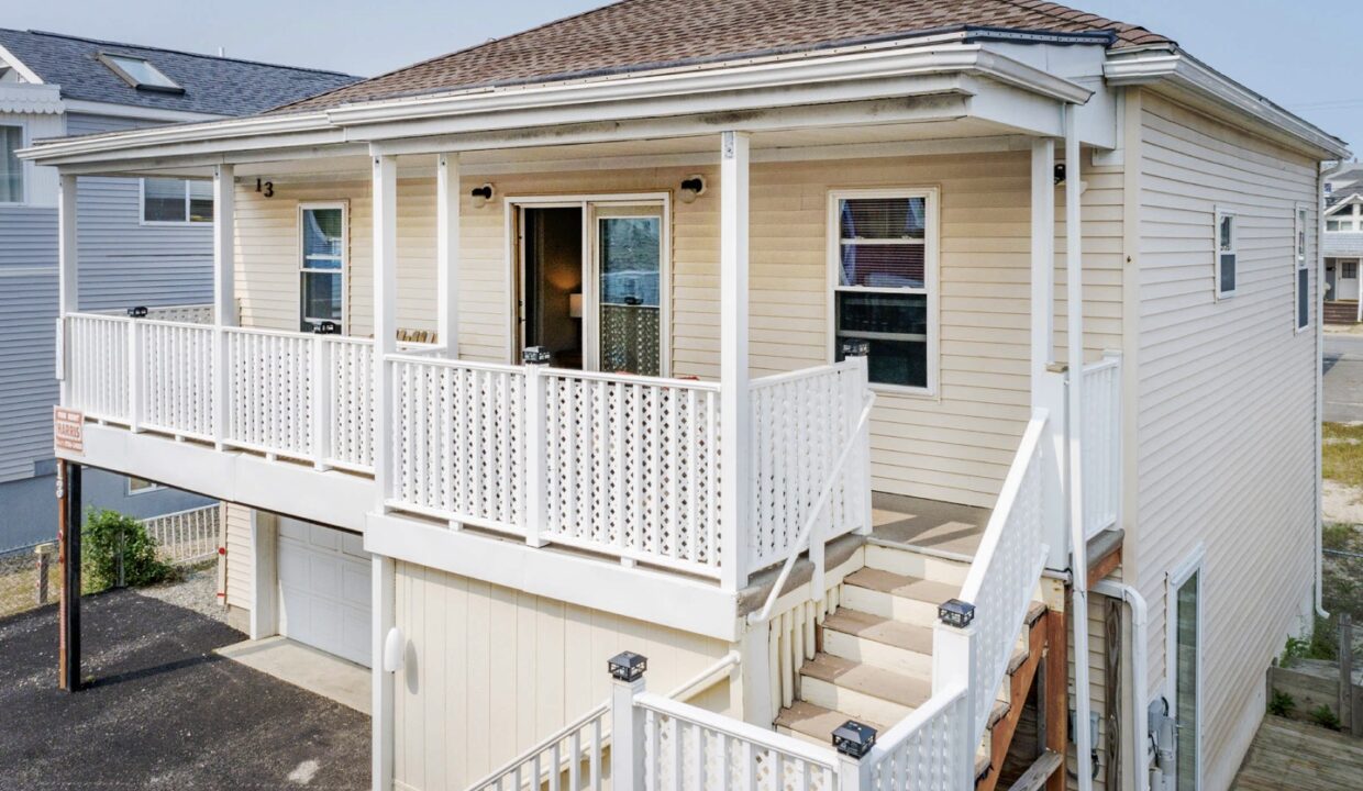 a white house with a porch and stairs.