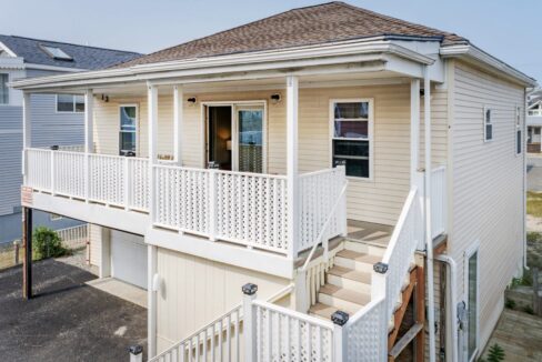 a white house with a porch and stairs.