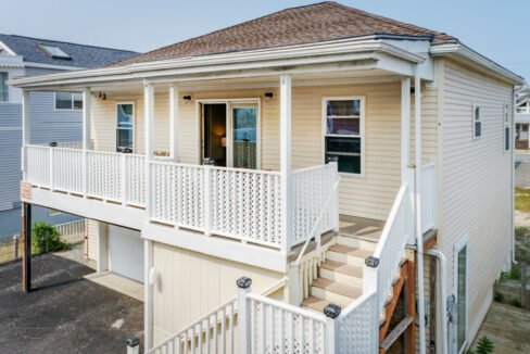 a white house with a porch and stairs.