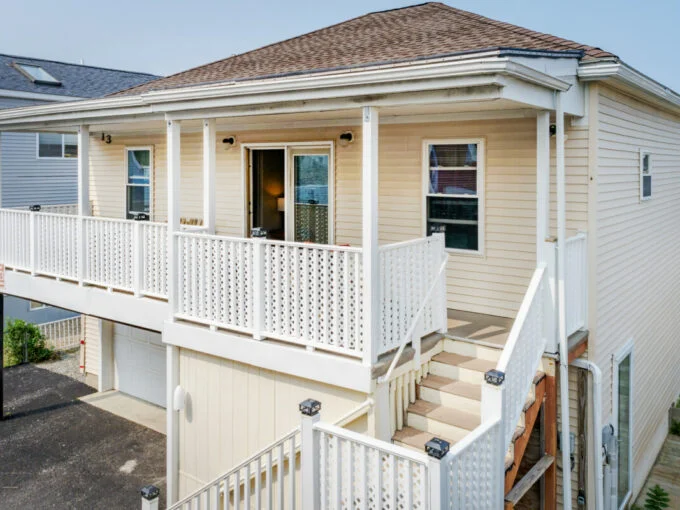 a white house with a porch and stairs.