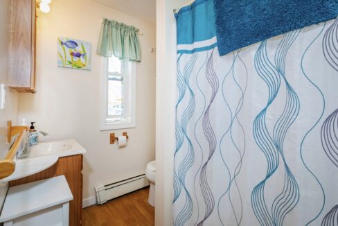 a bathroom with a sink, toilet, and shower curtain.