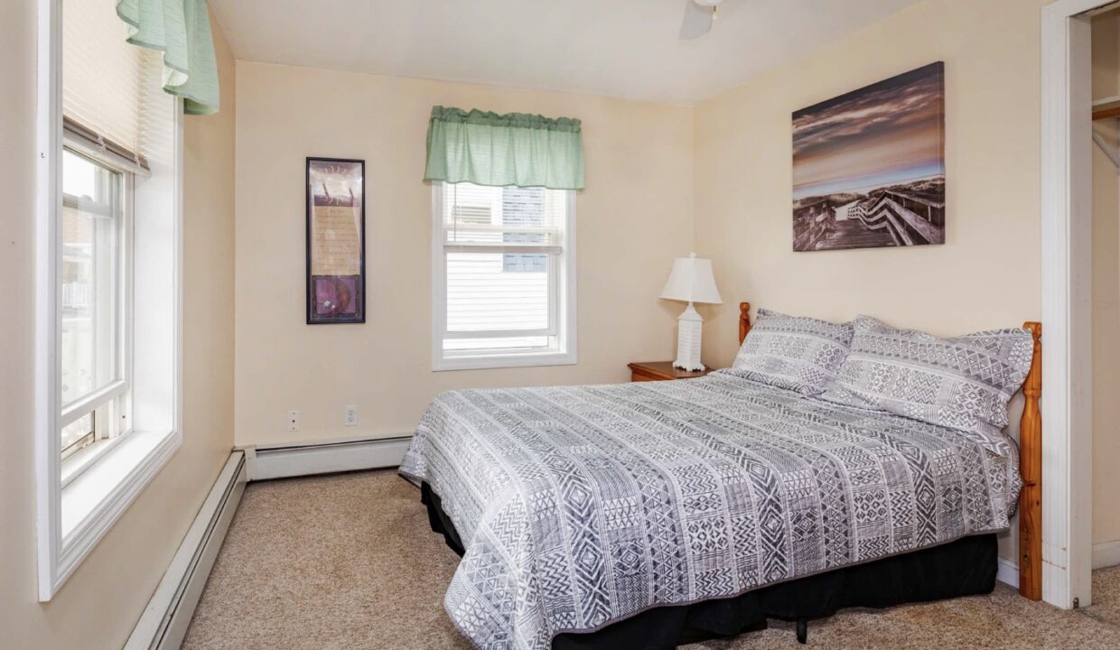 a bedroom with a bed and a ceiling fan.