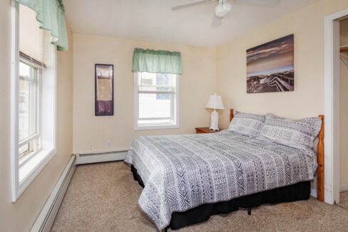 a bedroom with a bed and a ceiling fan.