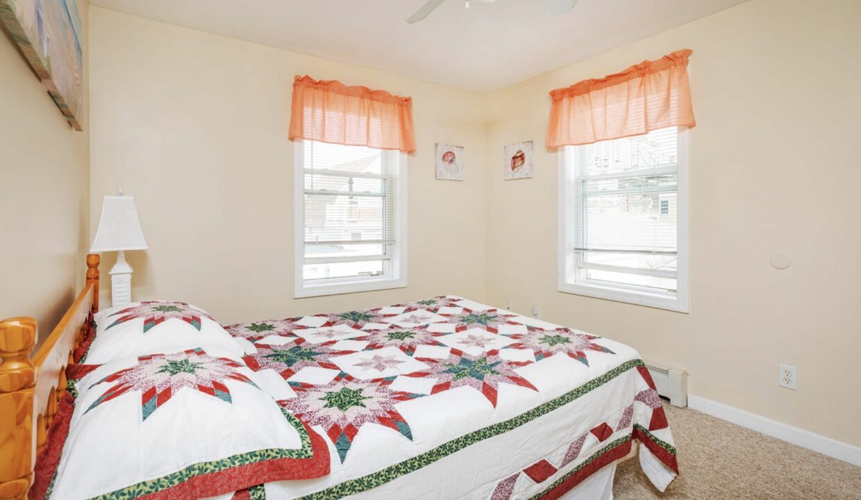 a bedroom with a bed and two windows.