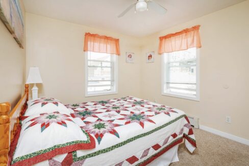 a bedroom with a bed and two windows.