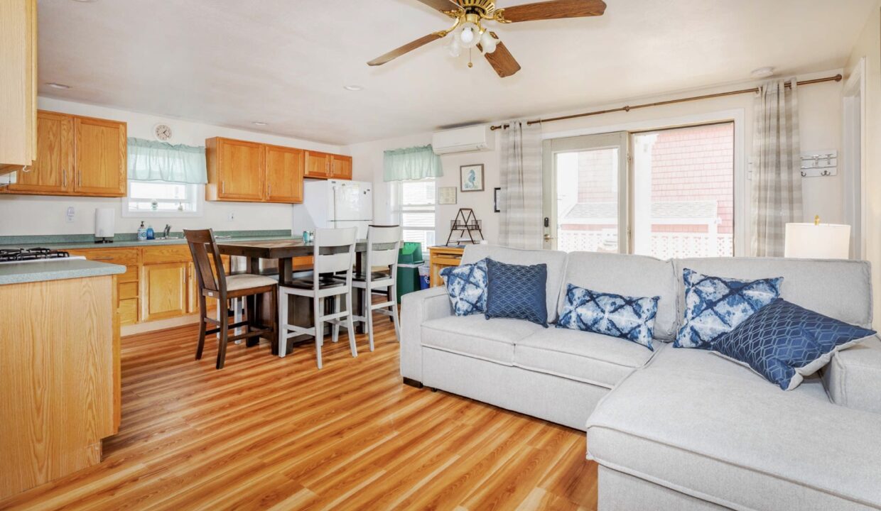 a living room filled with furniture and a kitchen.