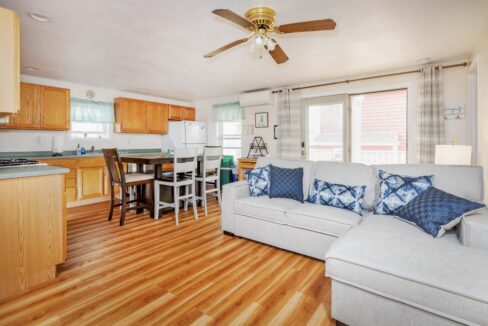 a living room filled with furniture and a kitchen.