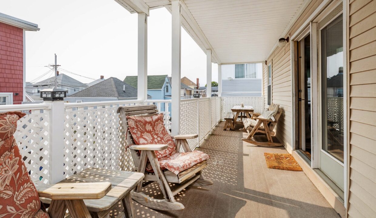 a porch with chairs and a table on it.