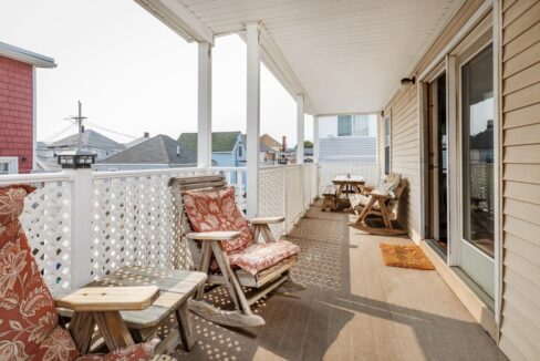 a porch with chairs and a table on it.