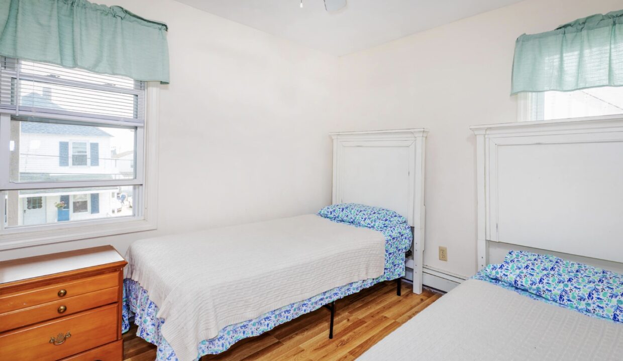 a bedroom with two beds and a dresser.