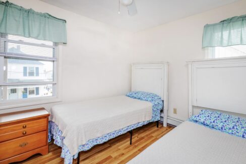 a bedroom with two beds and a dresser.