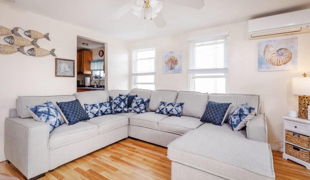 a living room filled with furniture and a ceiling fan.