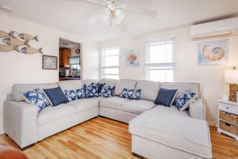 a living room filled with furniture and a ceiling fan.