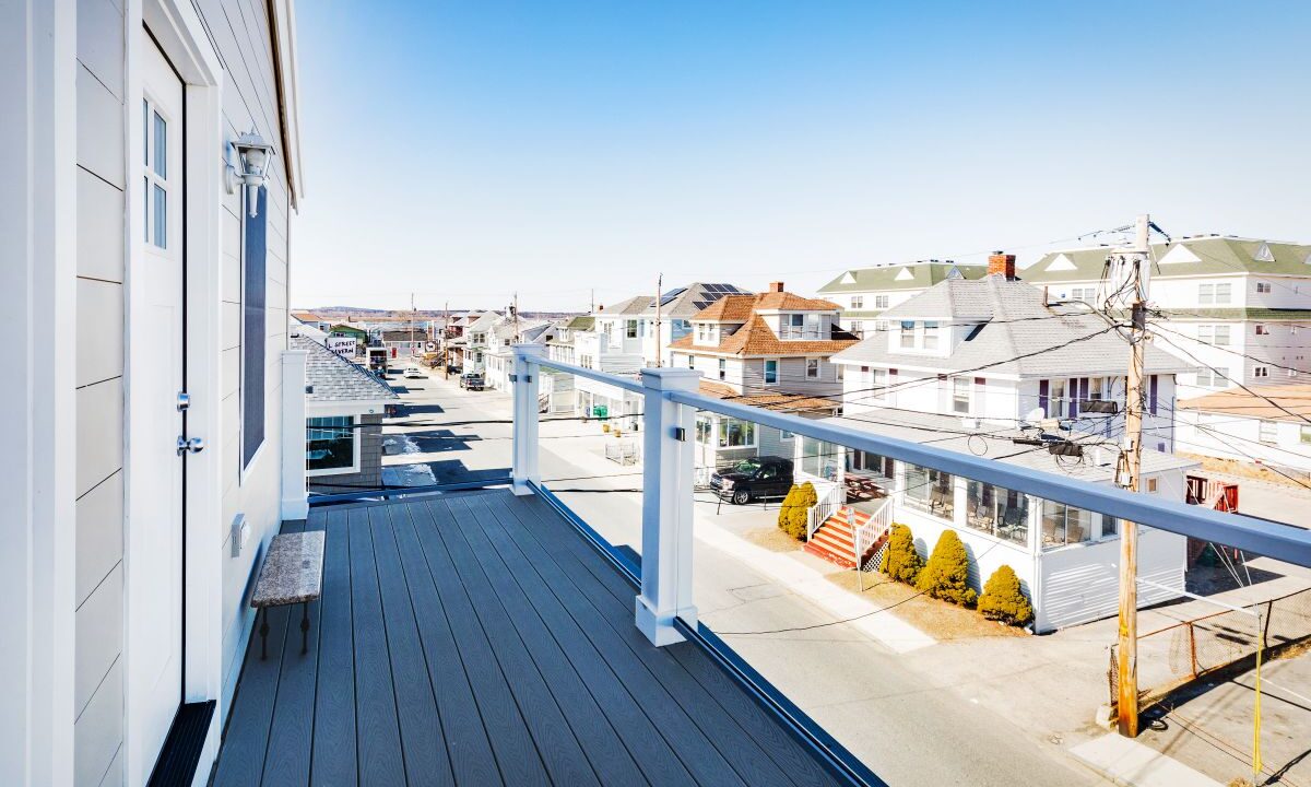 a balcony with a view of a street and houses.